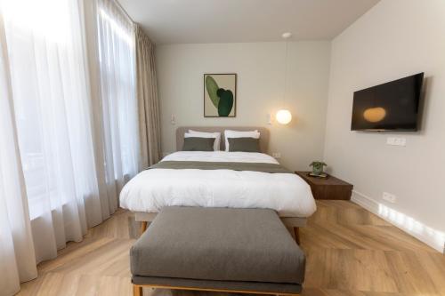 a bedroom with two beds and a flat screen tv at EL HOTEL - The Hague in The Hague