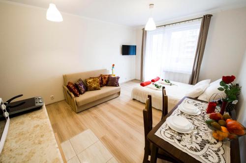 sala de estar con mesa y sala de estar con sofá en Apartament Polonijna en Cracovia