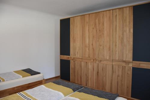 a bedroom with two beds and a large wooden cabinet at Biohof Weissensteiner in Ullrichs