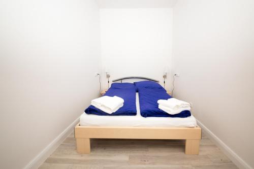 a small bed in a room with white walls at Schleiblick App 4 in Rabenkirchen-Faulück