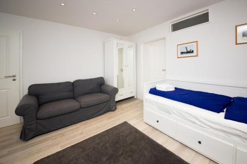 a living room with a couch and a bed at Schleiblick Familienappartement 13 in Rabenkirchen-Faulück