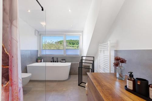 a bathroom with a tub and a toilet and a window at Hegauzauber in Tengen