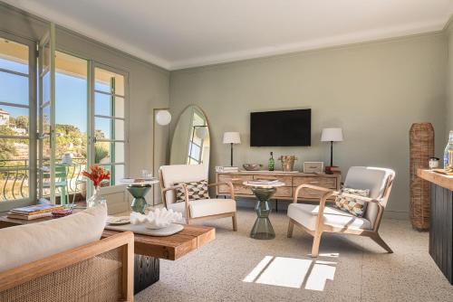 a living room with a couch and a tv at Maison Le Poete in Vallauris