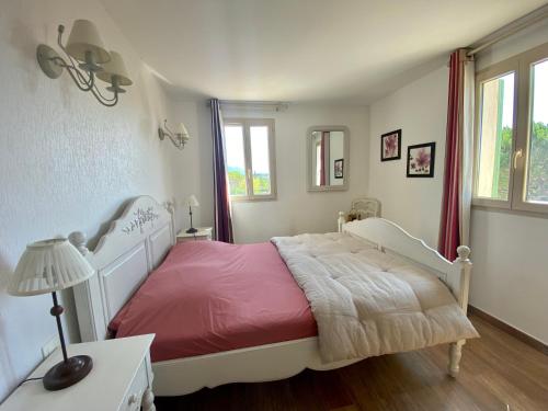 a white bedroom with a bed with a red blanket at La Bastide in Saint-Saturnin-lès-Apt