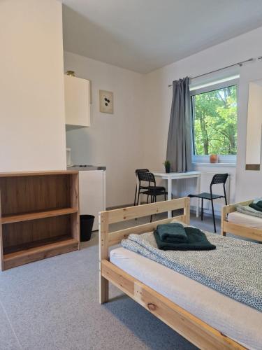 a bedroom with two beds and a table and chairs at Gruppenunterkunft für Firmen & Arbeiter in Laa an der Thaya in Laa an der Thaya