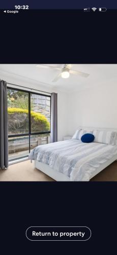 a bedroom with a white bed and a window at La Barca in Rye
