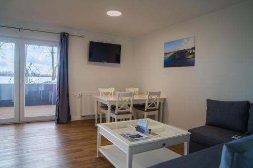 a living room with a table and a couch at Schleiblick App 17 in Rabenkirchen-Faulück