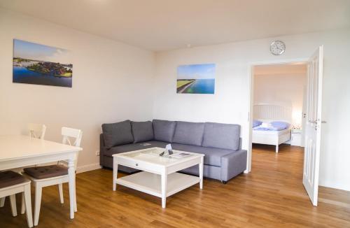 a living room with a couch and a table at Schleiblick App 17 in Rabenkirchen-Faulück