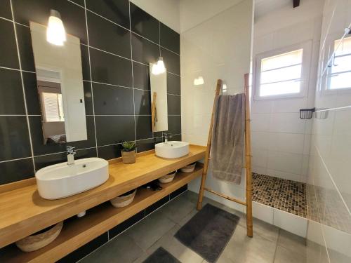 a bathroom with two sinks and a mirror at Évasion Tropicale - vue et plage à 2 min in Les Trois-Îlets
