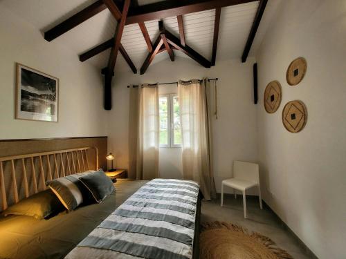 a bedroom with a large bed and a window at Évasion Tropicale - vue et plage à 2 min in Les Trois-Îlets