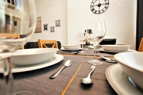 a wooden table with plates and glasses and spoons at Nixe in Dahme
