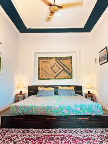 a bedroom with a large bed with two lamps at Comfort and Cozy in Orchha
