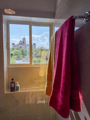 a bathroom with a purple towel hanging from a window at Comfort and Cozy in Orchha