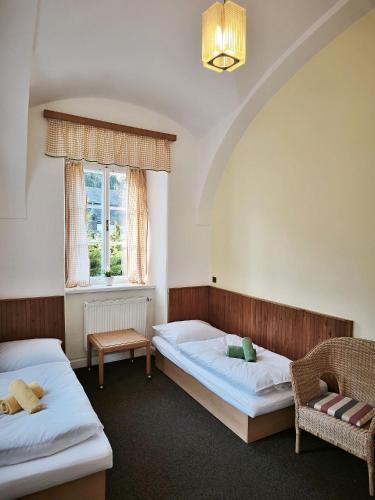 a bedroom with two beds and a window at Zámeček Bischofstein in Teplice nad Metují