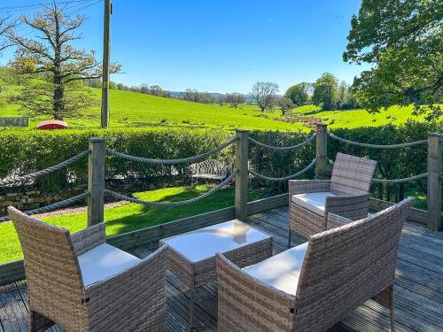 a deck with chairs and tables and a fence at Staffield Cottage - Uk35714 in Kirkoswald