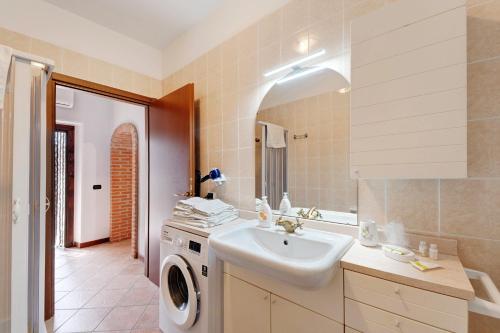 a bathroom with a sink and a washing machine at Centenario Affittacamere in Fara Novarese
