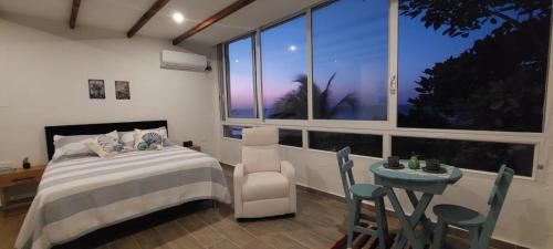 a bedroom with a bed and a table and a window at Puerto Beach House in Puerto Colombia