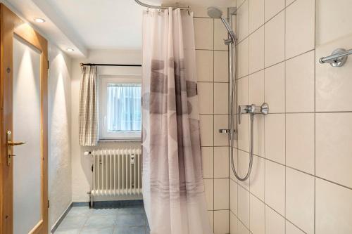 a shower with a white shower curtain in a bathroom at Haus Belchenwind in Münstertal