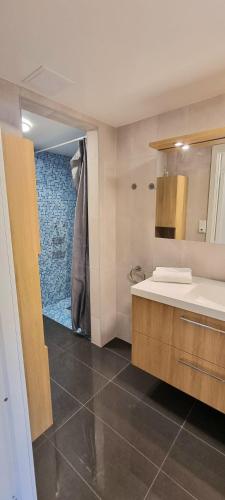 ein Badezimmer mit Waschbecken und Dusche in der Unterkunft Malinki Apartment in Ålesund