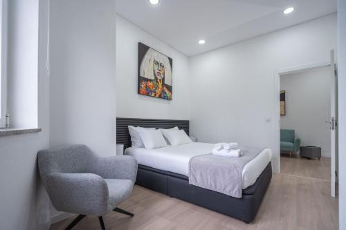 a bedroom with a bed and a chair at A Casa da Luísa in Vila Real