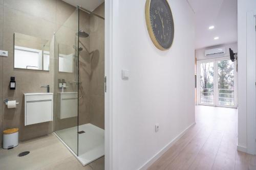 a bathroom with a shower and a clock on the wall at A Casa da Luísa in Vila Real