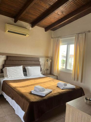 a bedroom with a bed with two towels on it at SunSet Boutique Hotel in Neos Marmaras