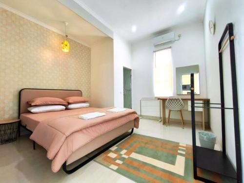 a bedroom with a large bed with pink sheets at Bo-Box Guesthouse & Female Only Capsule Lempuyangan - Khusus Wanita in Yogyakarta