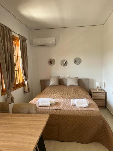 a bedroom with a large bed with two towels on it at Beautiful apartment with mountain view in Paralio Astros