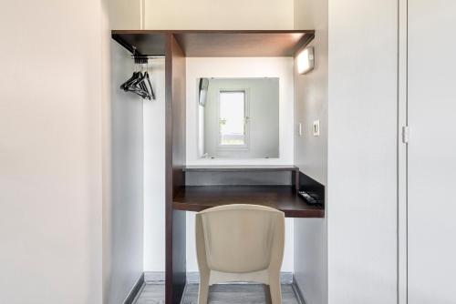 a room with a chair and a mirror at Fasthotel Angers Beaucouzé in Beaucouzé