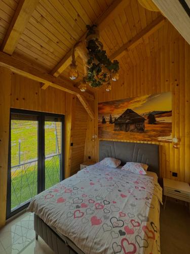 a bedroom with a bed in a wooden room at Vlasic Odmor - Villa Biser & spa in Vlasic