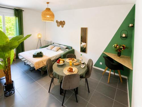 a bedroom with a bed and a table and chairs at " Souffle Vert " Wifi - TV - 4 personnes in Muret