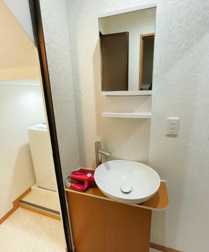 a bathroom with a white sink and a mirror at K-House in Tokyo