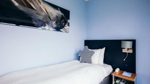 ein Schlafzimmer mit einem Bett und einem Bild an der Wand in der Unterkunft Delta Hotel in Vlaardingen