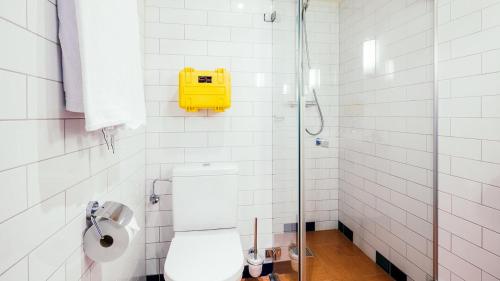 ein Badezimmer mit Toilette und einem gelben Kasten an der Wand in der Unterkunft Delta Hotel in Vlaardingen