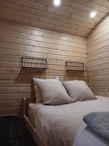 a bedroom with a bed in a wooden wall at La roulotte des foins in Montmaur