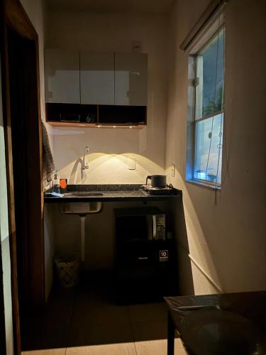 a small kitchen with a sink and a window at Studio Park e Mar a 600m do Beto Carrero in Penha