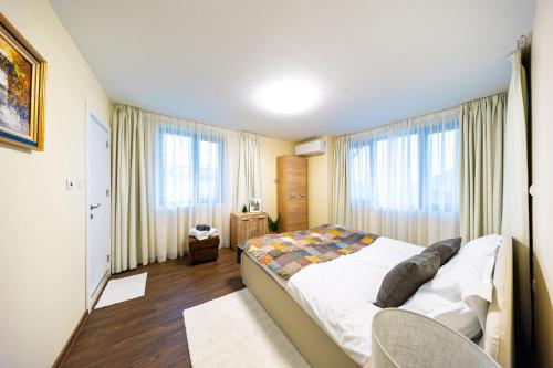 a bedroom with a bed in a room with windows at Вила "Люляк" in Lakarevo
