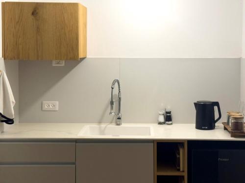a kitchen counter with a sink and a sink at michal Cozy Garden Unit & Jacuzzi in Kammon