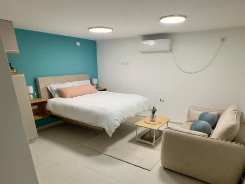 a bedroom with a bed and a couch at michal Cozy Garden Unit & Jacuzzi in Kammon