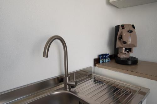 a kitchen sink with a coffee maker on a counter at Casa trani in Ischia