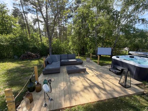 a wooden deck with a couch and a hot tub at Orfű Hillside in Orfű