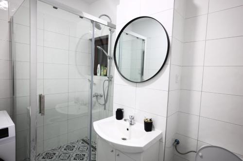 a white bathroom with a sink and a mirror at FLH - Sunset Horizon near Shopping City with parking in Şelimbăr