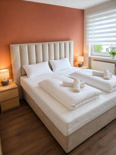 a large white bed with two white pillows on it at Hotel Panorama Nickenich in Nickenich