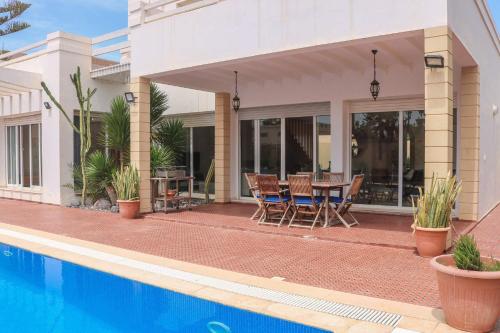 a house with a swimming pool and a table and chairs at Spacious 3 bed 2 bath villa with Garden and Pool in Mirleft