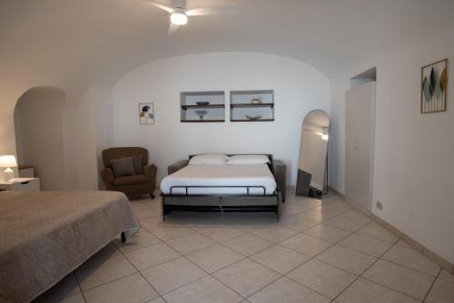a bedroom with a bed and a chair at Casa trani in Ischia
