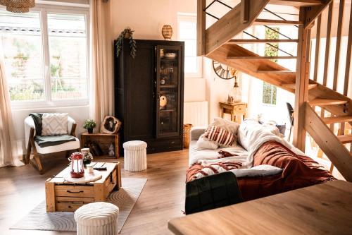 a living room with a couch and a staircase at La bohème Langogne in Langogne