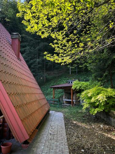 a building with a red roof and a walk way at Twin Forest, riverside cabin in Brod na Kupi