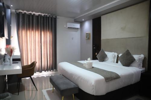 a hotel room with a bed and a desk and a bed and a table at Dikukama Executive Hotel in Tshabong
