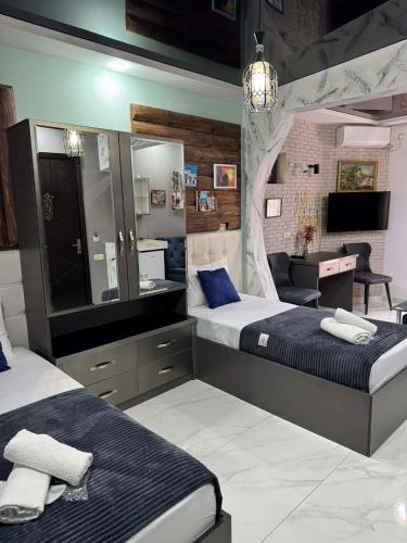 a bedroom with two beds and a mirror and a desk at Hotel City Building2 in Zugdidi