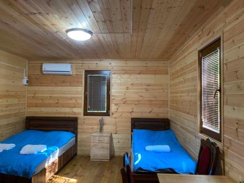 two beds in a cabin with wooden walls at Nika's house in Mtskheta